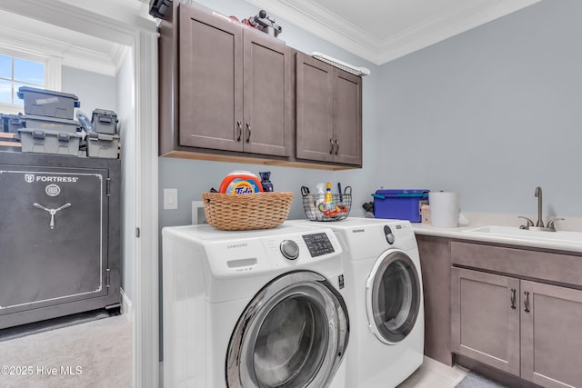 laundry room featuring crown molding, a sink, cabinet space, and washer and clothes dryer