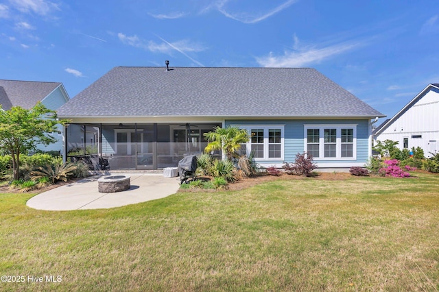 rear view of house with a patio, a fire pit, a yard, and a sunroom