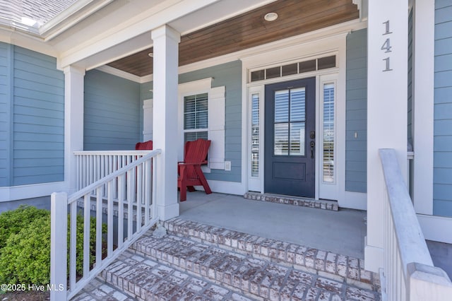 view of exterior entry featuring covered porch