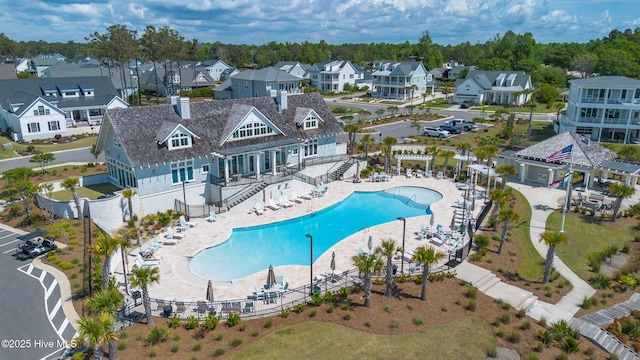 community pool featuring a pergola, fence, and a residential view