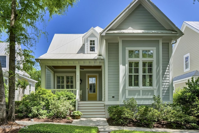 view of front of home featuring covered porch, metal roof, a ceiling fan, and a standing seam roof