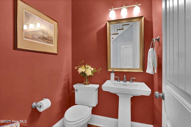 bathroom featuring baseboards and toilet