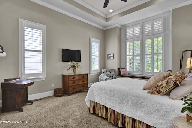 bedroom with ornamental molding, carpet, baseboards, a ceiling fan, and a tray ceiling