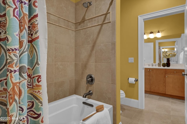 full bath with toilet, tile patterned floors, vanity, baseboards, and shower / tub combo