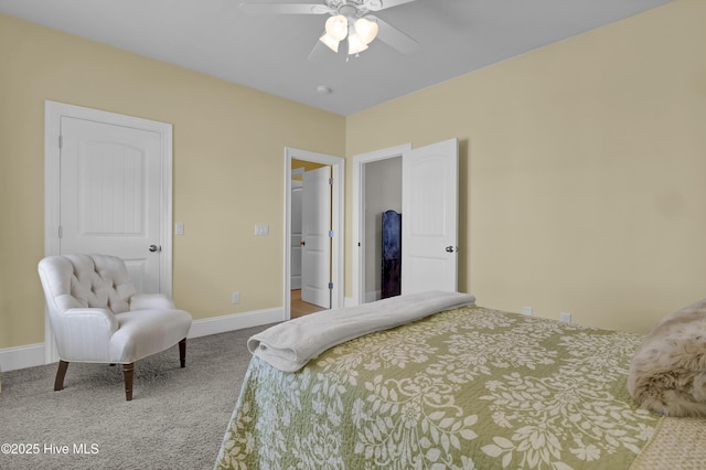 carpeted bedroom featuring baseboards, a walk in closet, and a ceiling fan