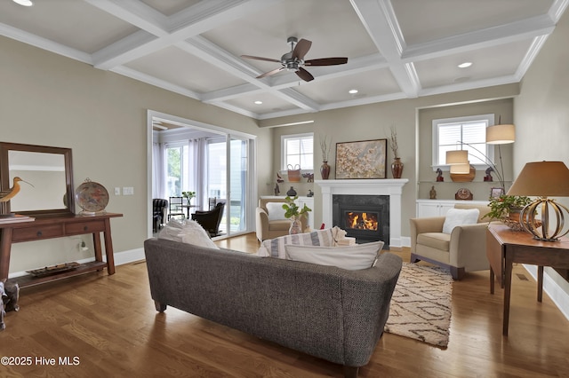 living room featuring a fireplace, coffered ceiling, wood finished floors, ceiling fan, and beam ceiling