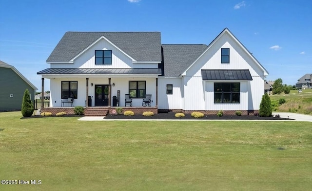 view of front of home with covered porch, a standing seam roof, metal roof, a front yard, and a shingled roof