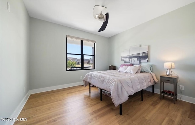 bedroom featuring a ceiling fan, baseboards, and light wood-type flooring