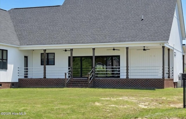 back of property featuring a yard, ceiling fan, and a shingled roof
