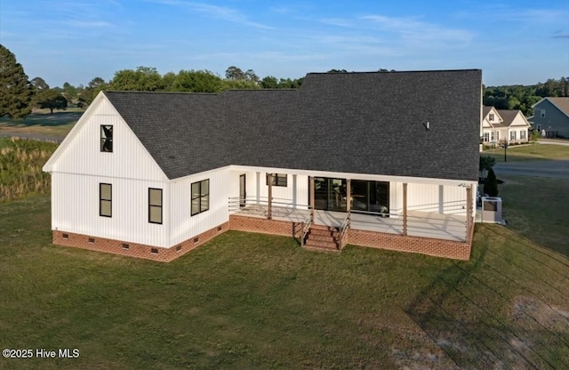 rear view of house featuring a yard, crawl space, and a shingled roof