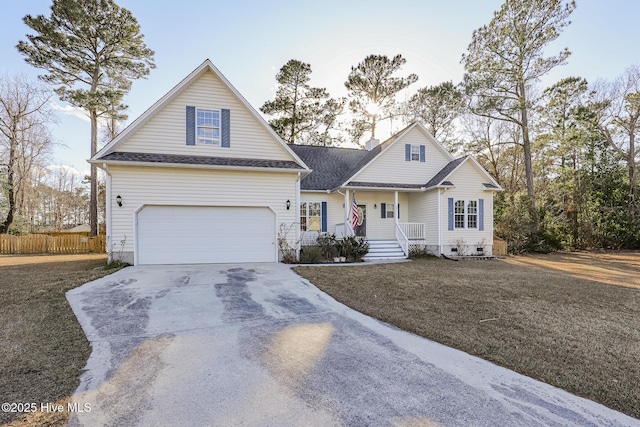 traditional-style home with covered porch, driveway, roof with shingles, fence, and an attached garage