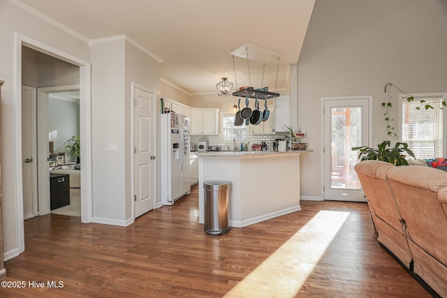 kitchen featuring dark wood finished floors, a peninsula, white cabinets, and a wealth of natural light