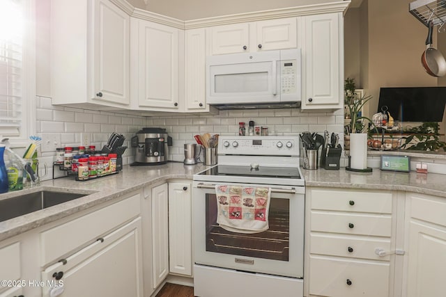 kitchen featuring white appliances, white cabinets, and decorative backsplash