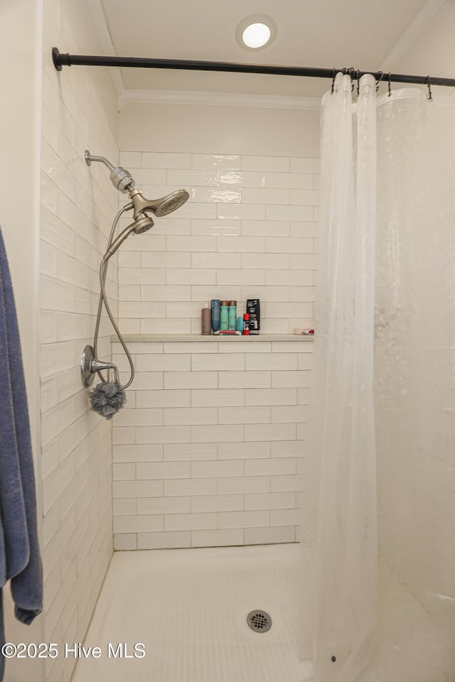 full bathroom with ornamental molding and a shower stall