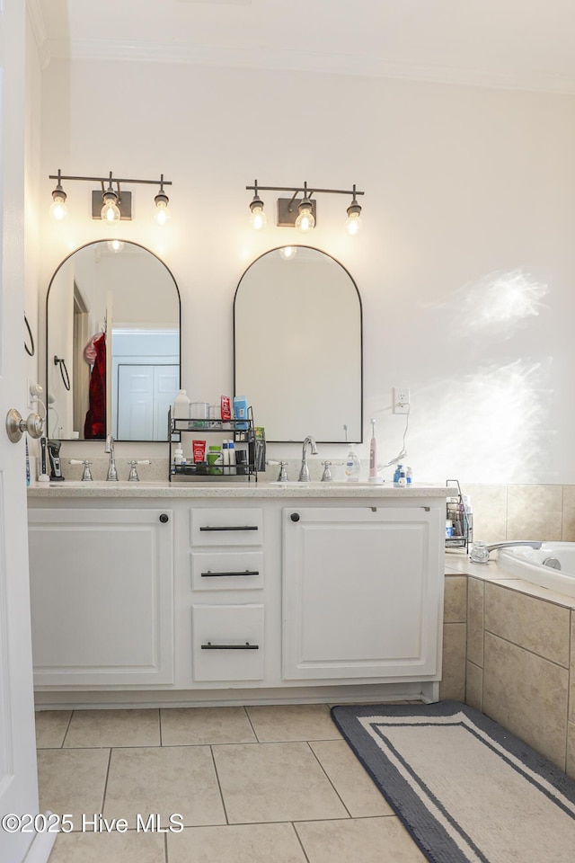 bathroom with a sink, tile patterned flooring, ornamental molding, and double vanity