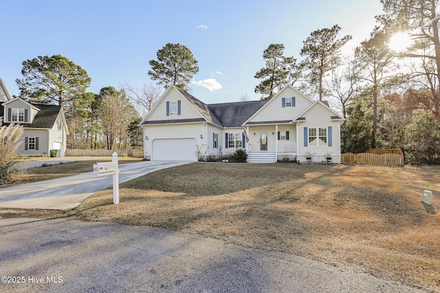 view of front of property featuring a porch, a garage, fence, and driveway