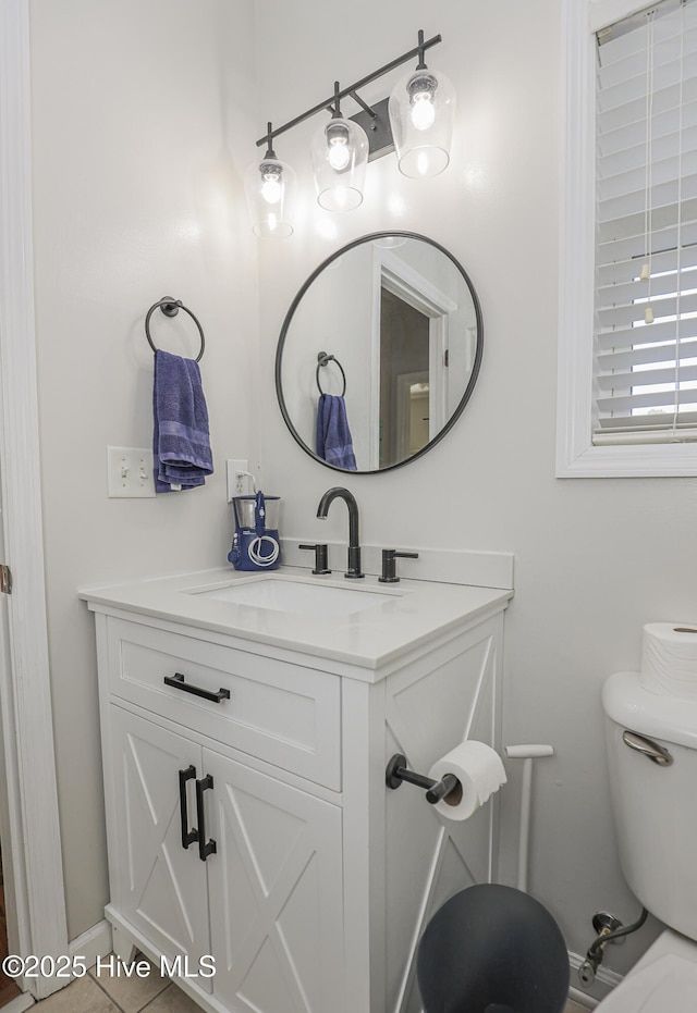 bathroom with vanity, baseboards, and toilet