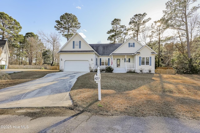 view of front of home with fence, covered porch, driveway, and a garage