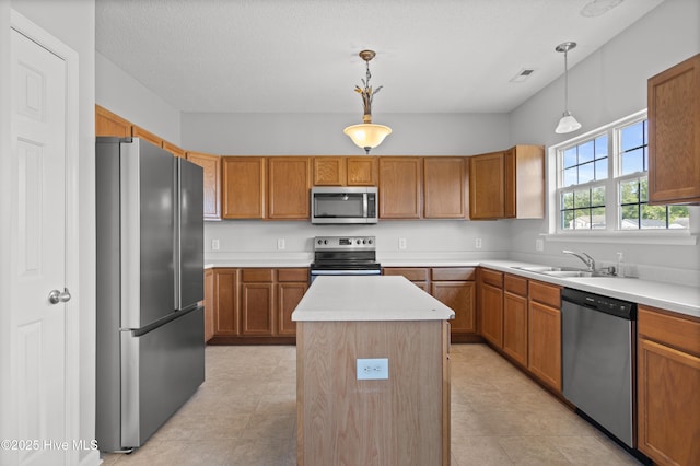 kitchen featuring a sink, a center island, stainless steel appliances, and light countertops