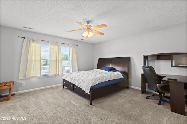 carpeted bedroom with ceiling fan, a textured ceiling, visible vents, and baseboards