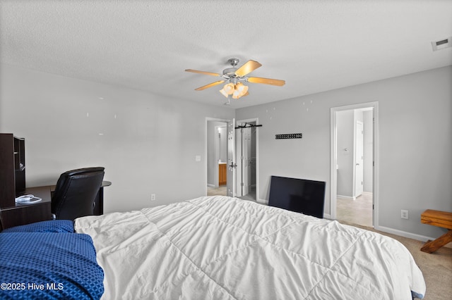 bedroom with visible vents, light carpet, baseboards, a textured ceiling, and a ceiling fan