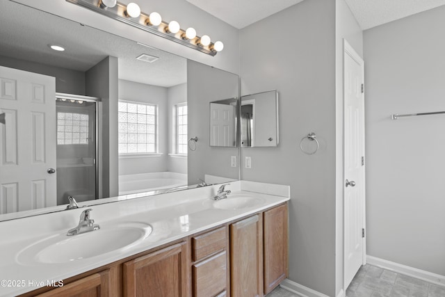 full bath with double vanity, a shower stall, a sink, and a bath