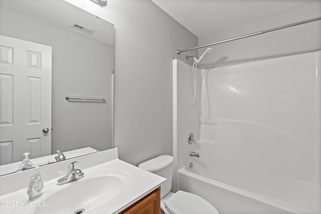 bathroom with visible vents, vanity, toilet, a textured ceiling, and shower / washtub combination