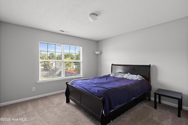 bedroom with baseboards, carpet flooring, and a textured ceiling
