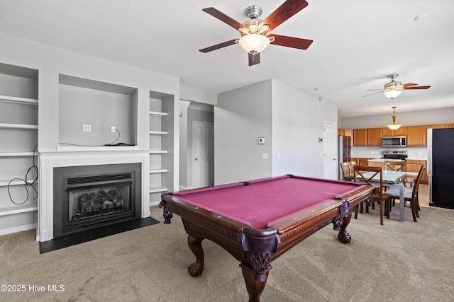 rec room with ceiling fan, light colored carpet, and a fireplace with flush hearth