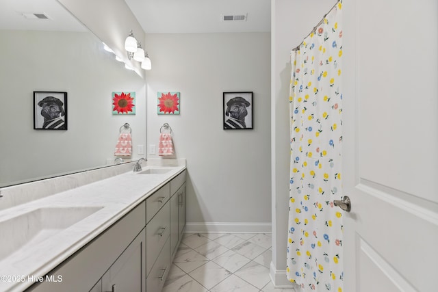 bathroom featuring a sink, visible vents, double vanity, and marble finish floor