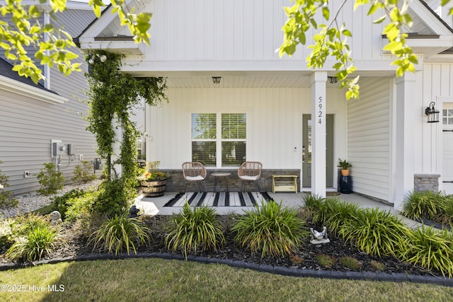 rear view of property with covered porch and board and batten siding