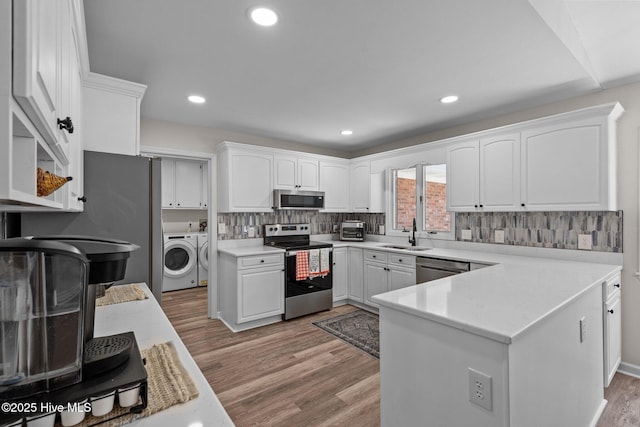 180 Lancashire Ln, West End, NC 27376 - kitchen featuring a sink, light wood-style floors, stainless steel appliances, white cabinetry, and washer and dryer