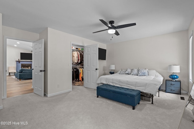 180 Lancashire Ln, West End, NC 27376 - carpeted bedroom with a closet, a fireplace, baseboards, a walk in closet, and ceiling fan