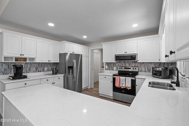 180 Lancashire Ln, West End, NC 27376 - kitchen with a sink, appliances with stainless steel finishes, decorative backsplash, and light stone countertops