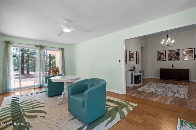 180 Lancashire Ln, West End, NC 27376 - living room featuring baseboards, wood finished floors, and ceiling fan with notable chandelier
