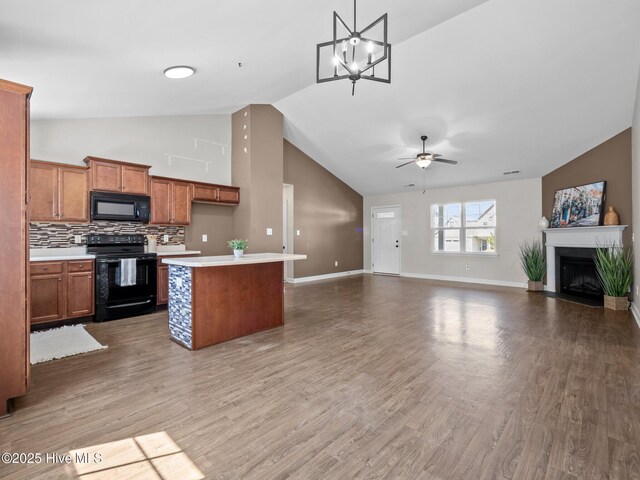 212 Peaceful Ln, Hubert, NC 28539 - kitchen featuring brown cabinetry, open floor plan, light countertops, ceiling fan with notable chandelier, and black appliances