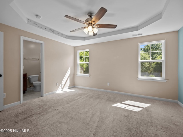 212 Peaceful Ln, Hubert, NC 28539 - unfurnished bedroom with carpet floors, baseboards, a tray ceiling, and visible vents