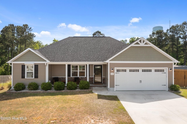 212 Peaceful Ln, Hubert, NC 28539 - view of front of home featuring fence, an attached garage, driveway, and a front lawn