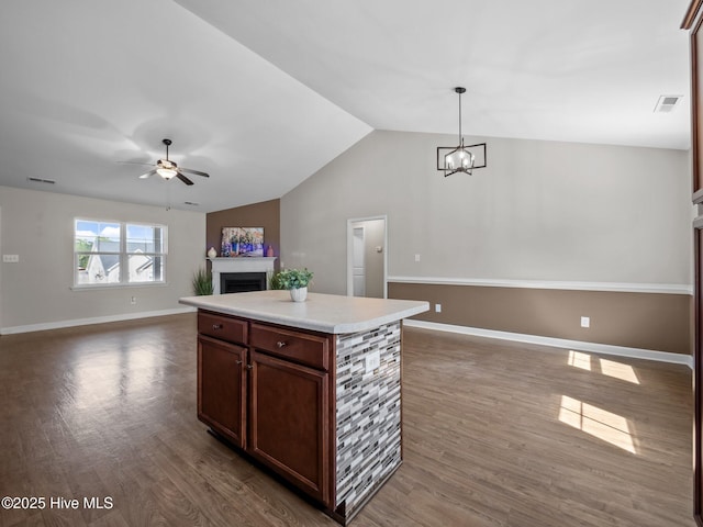 212 Peaceful Ln, Hubert, NC 28539 - kitchen featuring dark wood-style flooring, open floor plan, ceiling fan with notable chandelier, and a fireplace