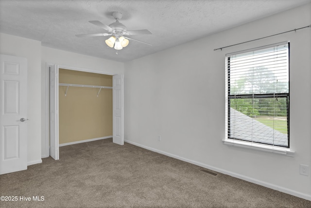 10165 Creekside Dr SE Apt 1, Leland, NC 28451 - unfurnished bedroom featuring carpet floors, a closet, baseboards, a textured ceiling, and a ceiling fan