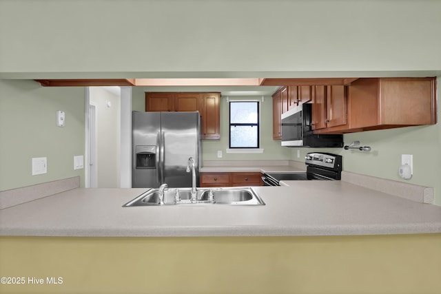 10165 Creekside Dr SE Apt 1, Leland, NC 28451 - kitchen featuring appliances with stainless steel finishes, a sink, a peninsula, and light countertops