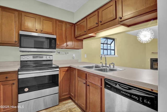 10165 Creekside Dr SE Apt 1, Leland, NC 28451 - kitchen featuring appliances with stainless steel finishes, a sink, and brown cabinets