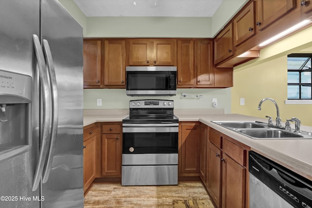 10165 Creekside Dr SE Apt 1, Leland, NC 28451 - kitchen featuring stainless steel appliances, a sink, and brown cabinets