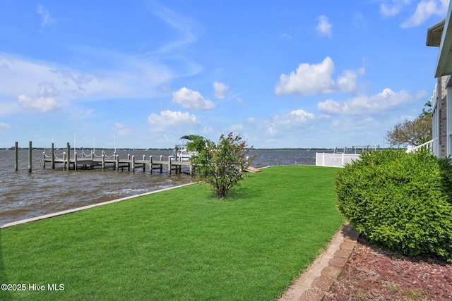 dock area featuring a lawn, boat lift, and a water view