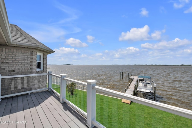 dock area with a lawn, a water view, and a balcony