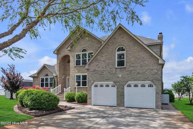 traditional home with an attached garage, brick siding, driveway, and a chimney