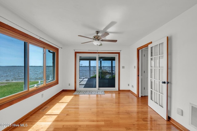 unfurnished room featuring visible vents, light wood-style floors, and baseboards