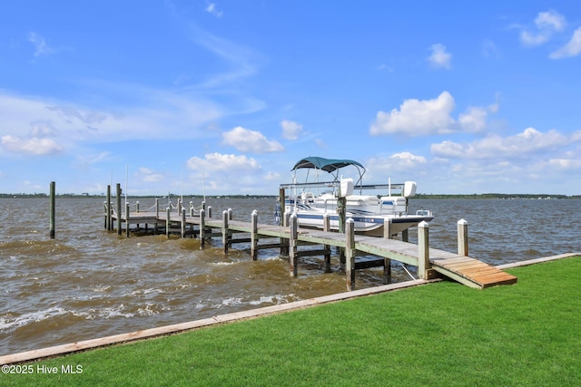 dock area with a yard, boat lift, and a water view