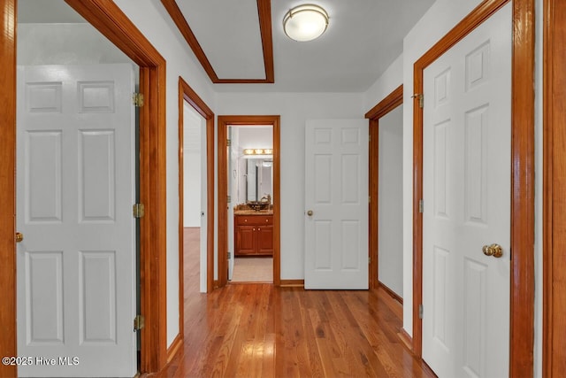 hall with baseboards and light wood-style floors