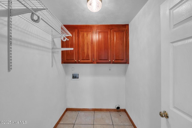 laundry area with cabinet space, light tile patterned flooring, baseboards, and hookup for a washing machine